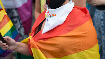 LGBT equality march. Young people wearing rainbow clothes and symbols are fighting for LGBTQ+ rights. Rainbow flags, banners.
