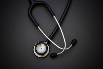 Black stethoscope on black background. World health day and healthcare concept. Black stethoscope for doctor diagnostic coronavirus disease.
