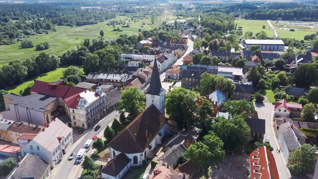 Aerial View of the  Holy Trinity Lutheran Church in Tukums, Latvia. Golden Cock Statue on the Top of Tower. Tukums City Park on the  the Background. Sunny Summer Day.