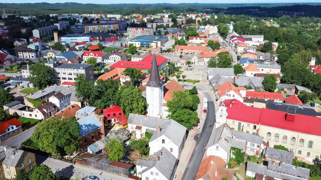 Aerial View of the  Holy Trinity Lutheran Church in Tukums, Latvia. Golden Cock Statue on the Top of Tower. Tukums City Park on the  the Background. Sunny Summer Day.
