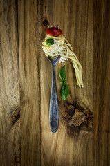 Spaghetti with tomato and basil on the fork - still life