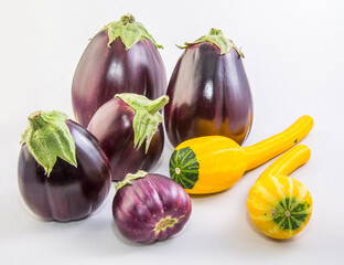 Group of eggplant and zucchini on a white plate on a white background.