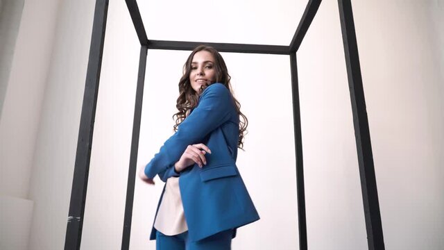 fashionable girl in a business suit dancing on a white background