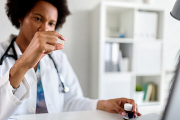 Stressed medical worker working at her office taking pill