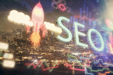 SEO hologram on city view with skyscrapers background double exposure. Search optimization concept.