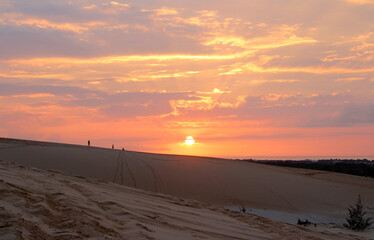Fototapeta premium Beautiful sunrise with dramatic cloudscape at White Sand Dunes in Mui Ne, Vietnam