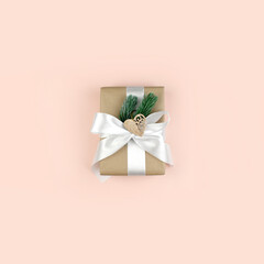 Minimalist Christmas composition in trendy pastel color. Gift or present box on pink background. Eco friendly design. Top view, copyspace.