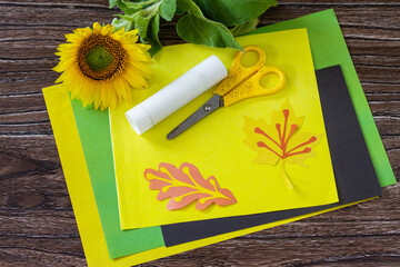 Instructions, step 1. Gift from a paper, sunflower flower on a wooden table. Childrens art project, handmade, crafts for children.