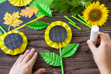 Instructions, step 11. Gift from a paper, sunflower flower on a wooden table. Childrens art...