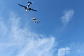 Fototapeta na wymiar Skydiving. A military girl is flyingin the sky.