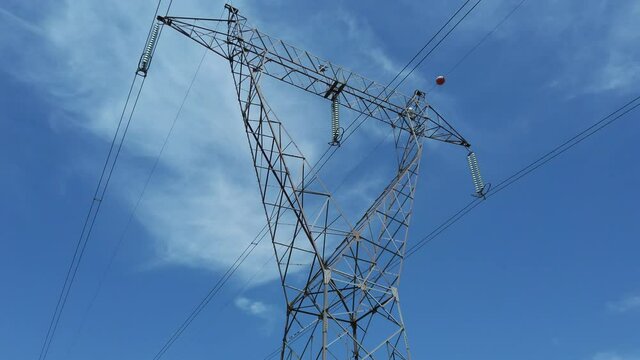 high voltage transmission line tower on blue sky