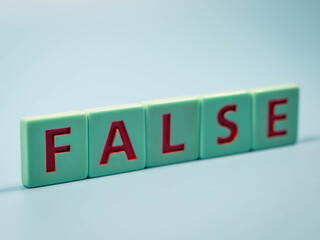 FALSE word of red letter cubes on a blue background. 