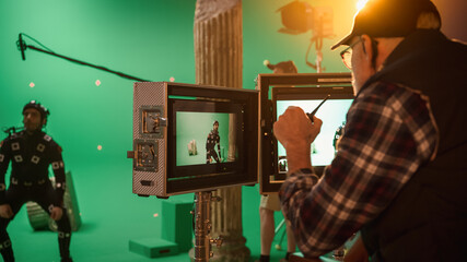 Director Looks at Displays Directs Green Screen CGI Scene with Actor Wearing Motion Tracking Suit...