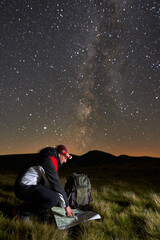 Man hiking at night under starry sky