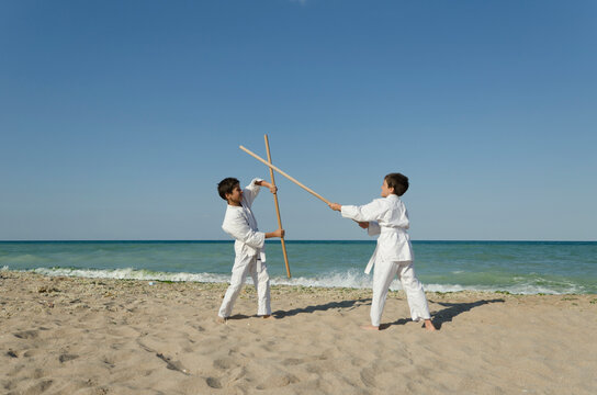 Kids practicing Aikido on the beach. Healthy lifestyle and sports concept