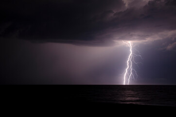 Naklejka na ściany i meble Flash of lighting during a summer storm in the Black Sea