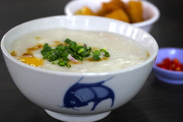 A common and simple street food in Asia - Rice Porridge or Congee with Egg and served with Fried Dough Stick