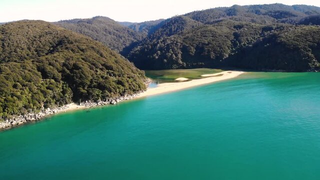 Sandfly Bay aerial fly forward to the beach crossing the sea shot. Abel Tasman, New Zealand. Nice warm day, clear sunny sky.