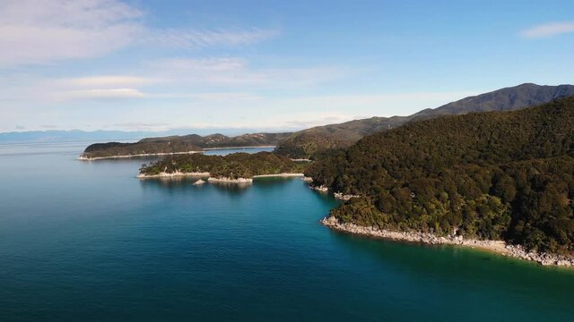 Beautiful landcape of New Zealand Abel Tasman Coast aerial fly backward shot. Nice sunny day in pure nature paradise.