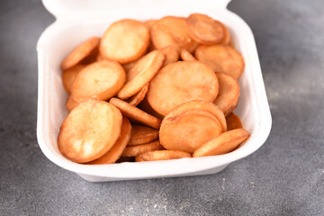 Golden fried potatoes in a plastic box, delivered fast food.