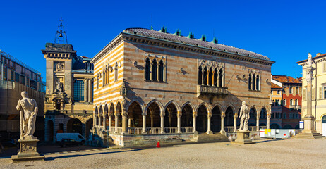 Fototapeta na wymiar View of Gothic building of Loggia del Lionello - town hall of Udine on central city square of Piazza liberta in sunny day, Italy