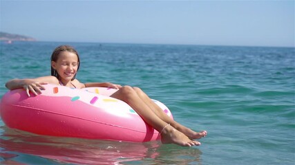Adorable girl on inflatable air mattress in the sea
