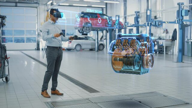 Car Service Manager Uses a Futuristic Virtual Reality Headset Diagnostics Gadget with Controllers. Specialist Inspecting the V6 Internal Combustion Engine for Parts and Component Numbers.