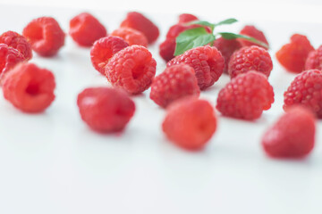 
Raspberries on a white plate and with mint in the middle.