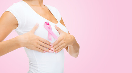 health, medicine and people concept - close up of young woman checking breast with cancer awareness...