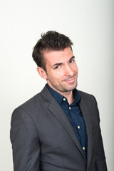 Portrait of young handsome Hispanic businessman in suit