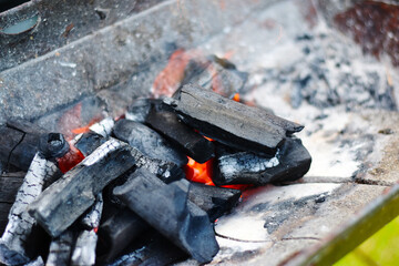 Closeup of charcoal burning under a barbecue grill