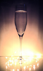 a glass of carbonated drink in a glass on a pink background