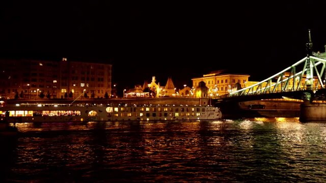 A boat passes under Bridge aser show on the Danube River
