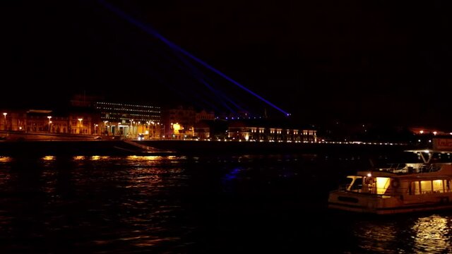 A boat passes under Bridge aser show on the Danube River
