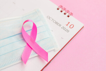 Breast Cancer concept : Top view pink ribbon, protective mask and calendar symbol of breast cancer...