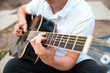 Fototapeta na wymiar Close up photo of man playing at acoustic guitar.