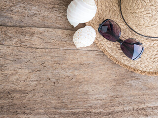 Top view summer accessories with hat and glasses on old wood background.
