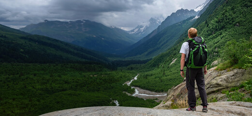 Fototapeta na wymiar Man hiking at mountains with heavy backpack.