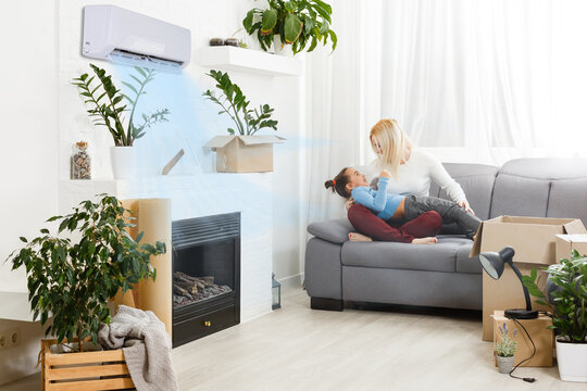 air conditioning in living room with happy family moving to new apartment