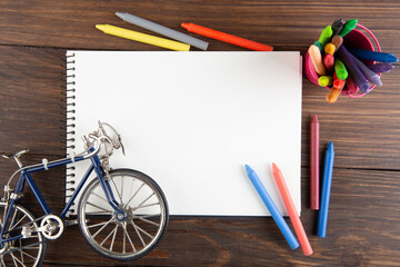 colored crayons and blank page on the wooden table