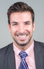 Portrait of happy young handsome Hispanic businessman in suit