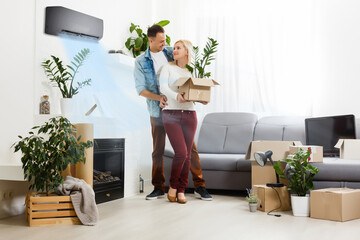 air conditioning in living room with happy family moving to new apartment