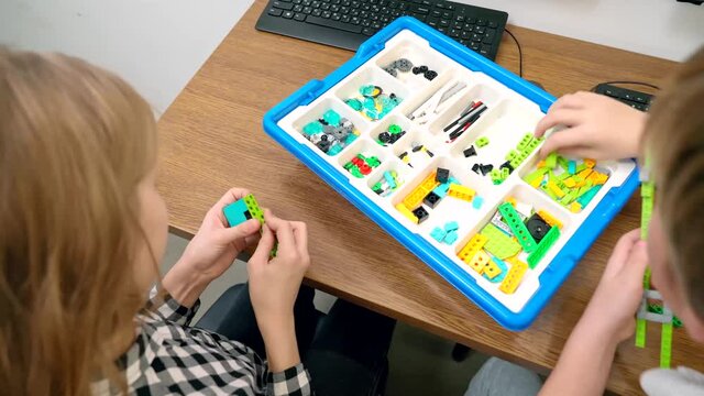 Children using building kit in classroom.
