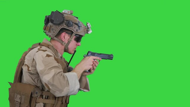 Soldier aiming and shooting with a pistol on a Green Screen, Chroma Key.