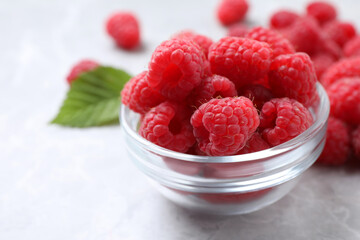 Delicious fresh ripe raspberries on light grey table, closeup