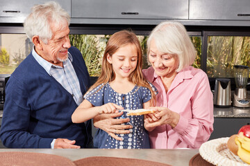 Großeltern und Mädchen beim Brot schmieren