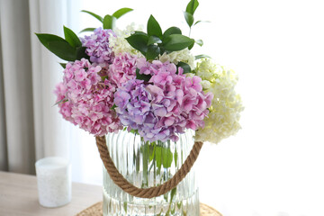 Bouquet of beautiful hydrangea flowers on table near window. Interior design