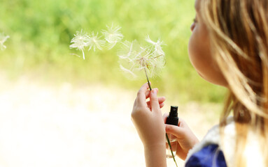Portrait of cute girl with dandelion outdoor