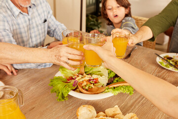 Familie beim Anstoßen mit gesundem Orangensaft