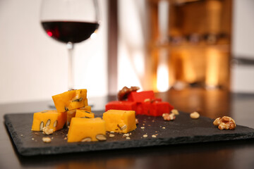 Delicious gouda cheese and walnuts on table, closeup